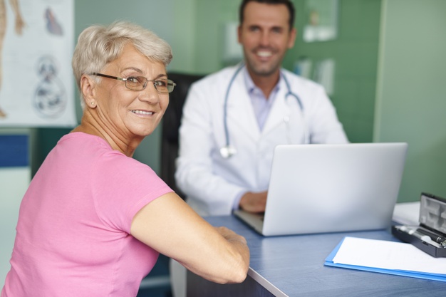Imagem mostra paciente feliz com médico usando receita digital